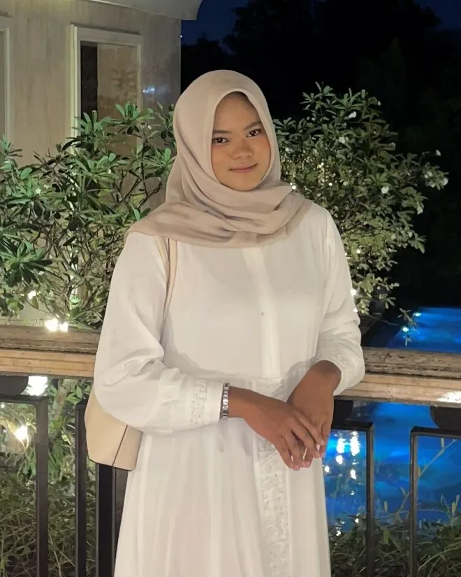 Portrait of Nisrina Putri in a white dress and a beige hijab